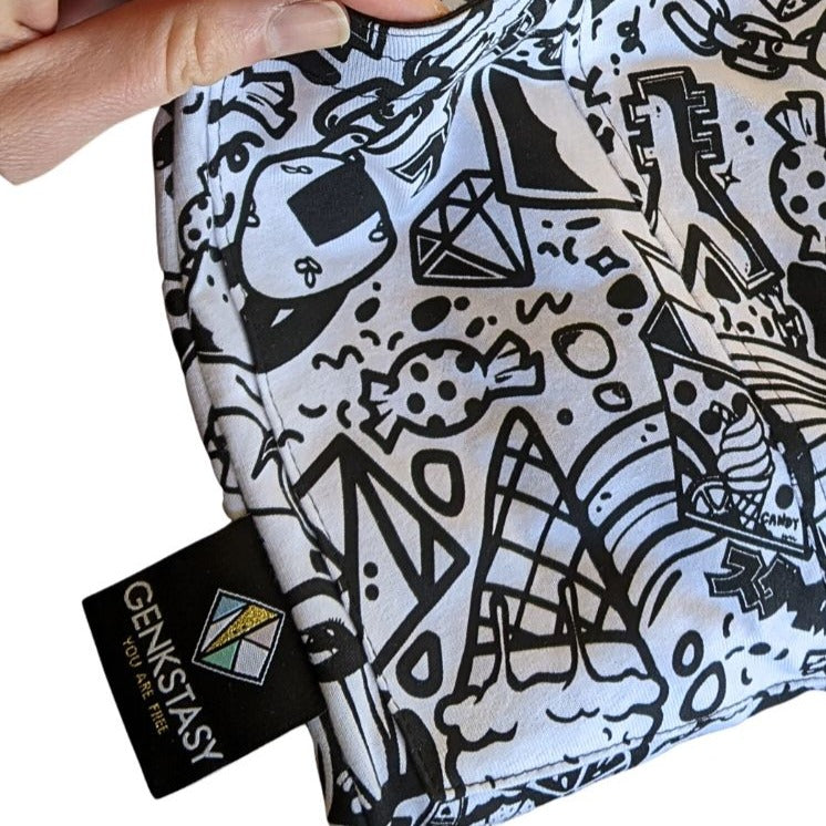 Close up of the printed organic cotton fabric, you can see the softness of the fabric and the clarity and high quality of the black print which features japanese characters, symbols, the genstasy logo, and kawaii things like ice cream cones, diamonds, chains, lollies, onigiri, and cute femmish characters in a strong graphic style. 