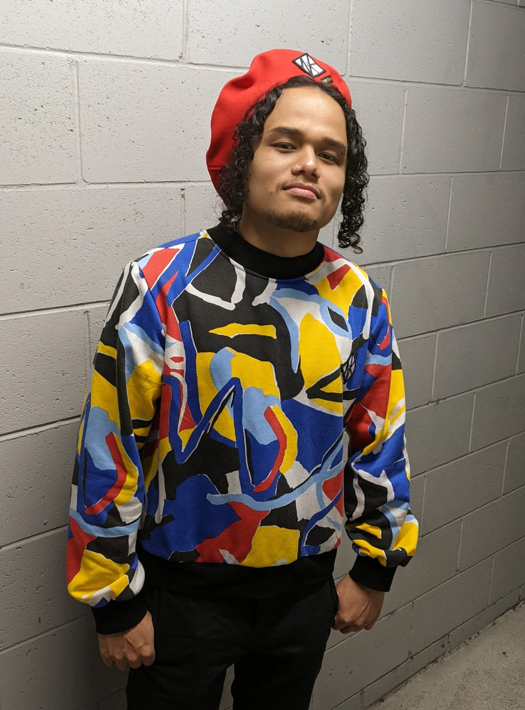 In this image Feng wears the Tidal Jumper with a red GNK Beret, which matches the red in the patter on the jumper.